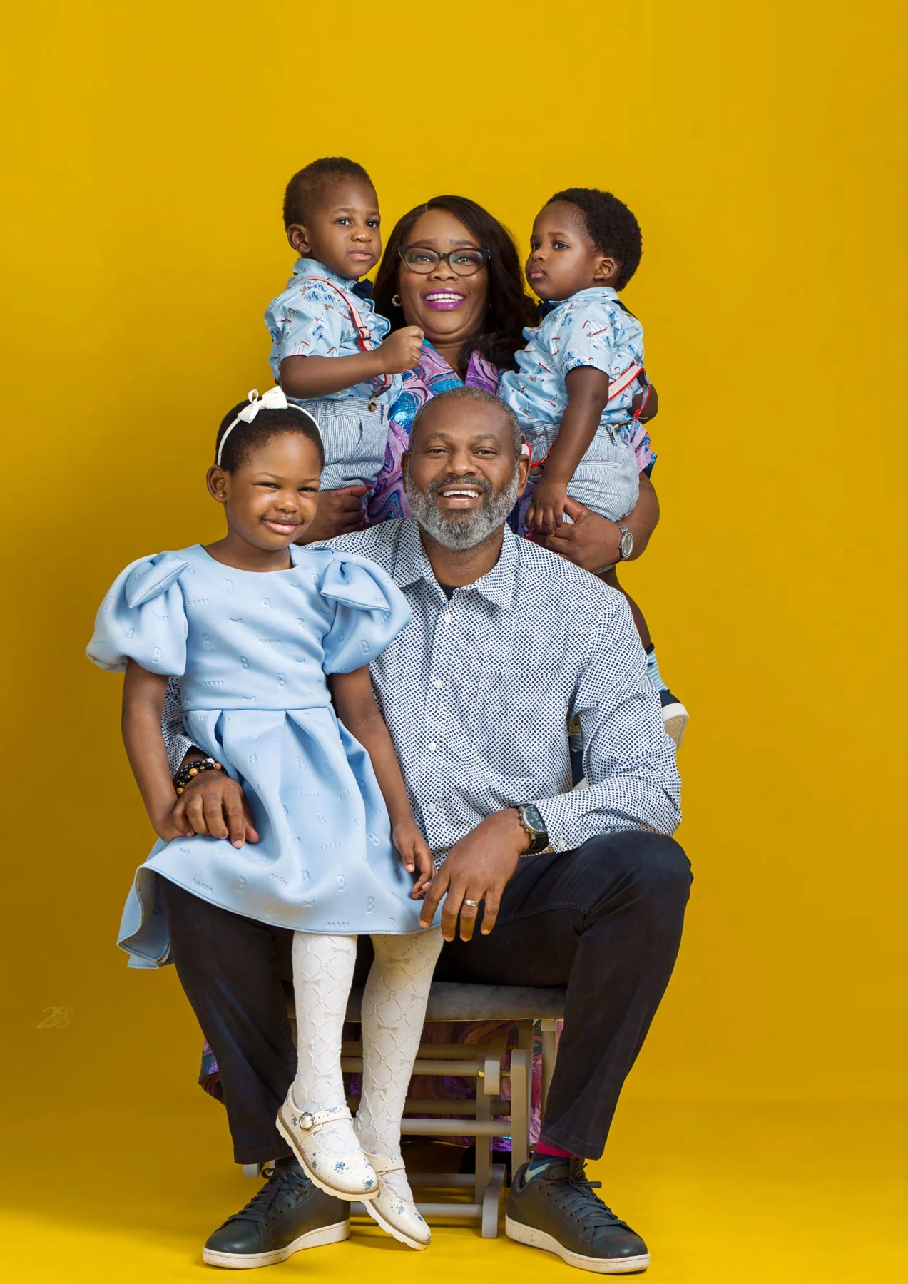 Family together against a yellow backdrop